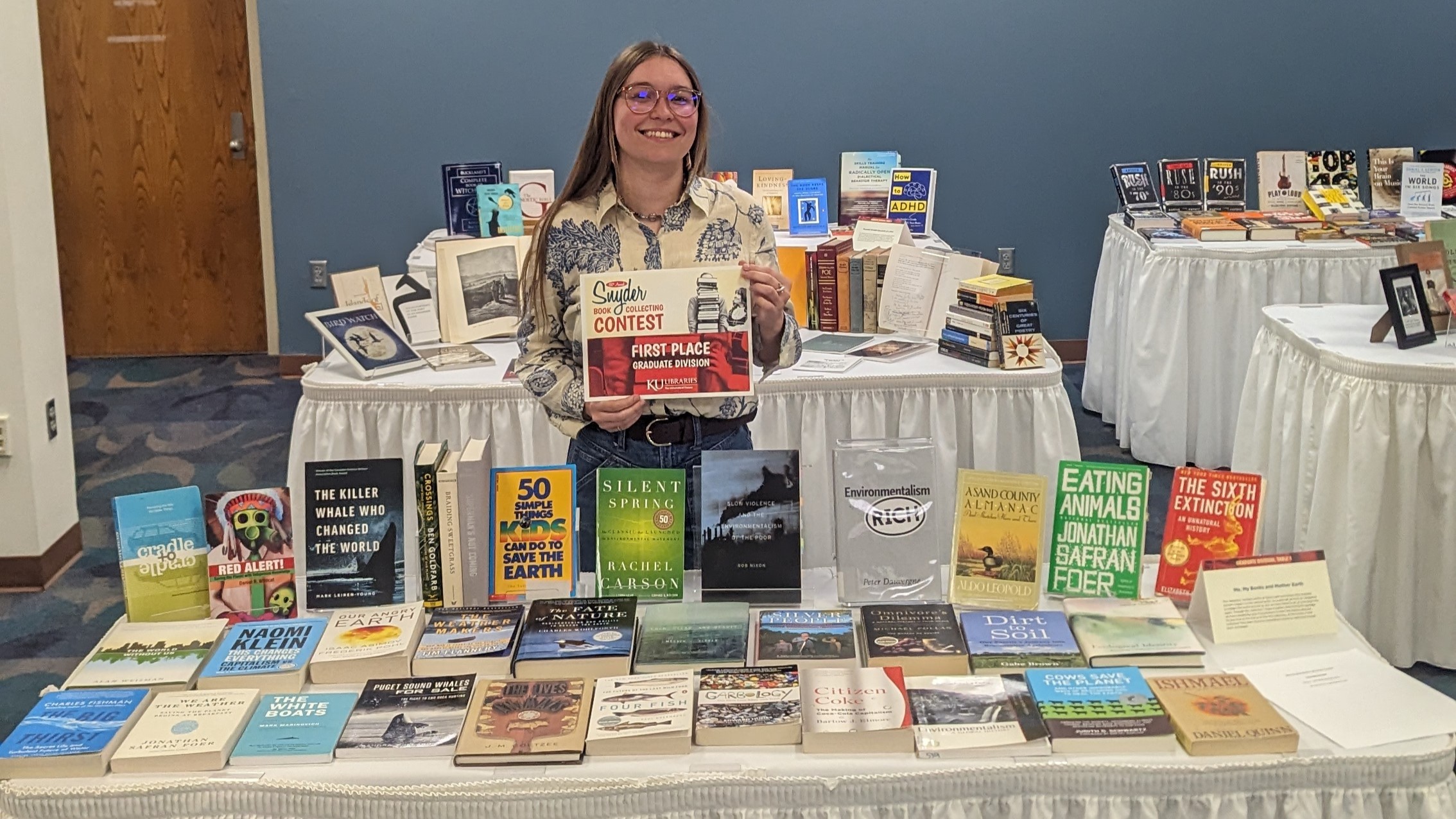 Emma next to table showing her book collection
