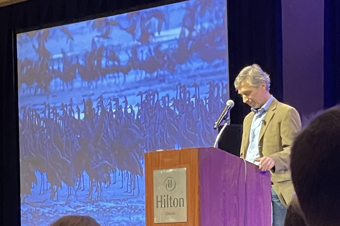 Photographer Forsberg at podium with sandhill cranes on screen