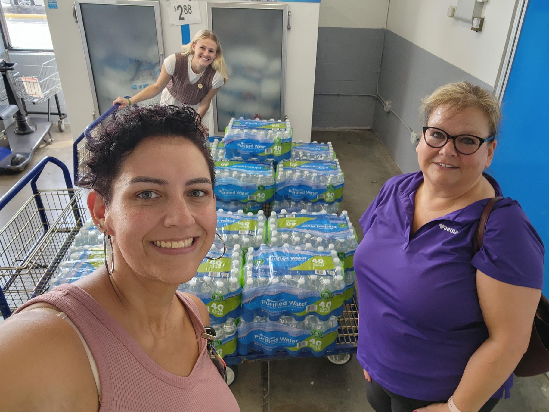 Two people with cases of water